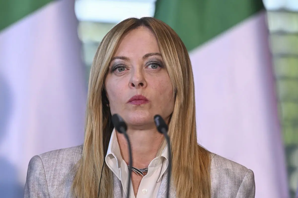 Giorgia Meloni parla con il microfono durante un vertice a Berlino