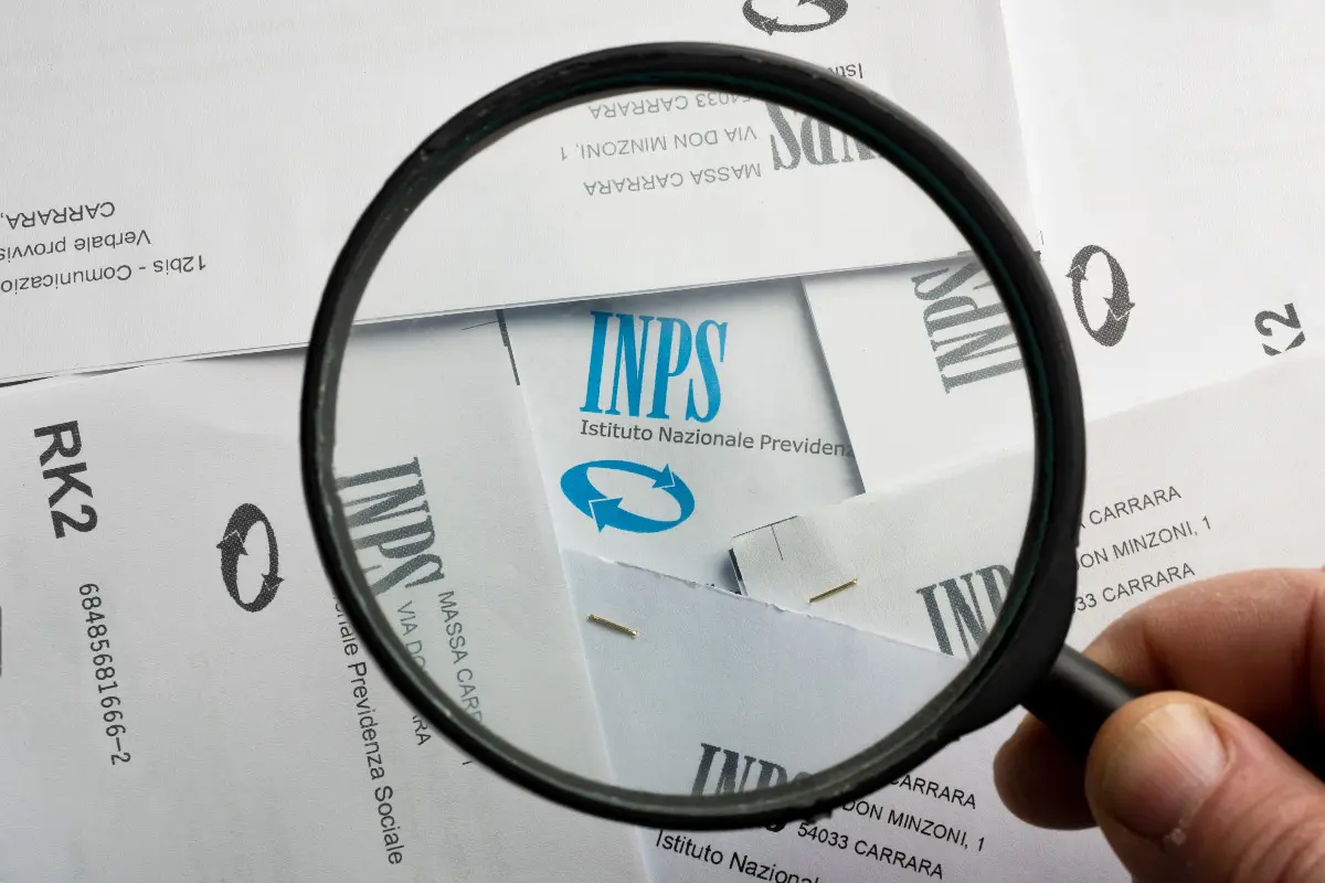 Il logo dell’INPS accanto a una lente di ingrandimento
