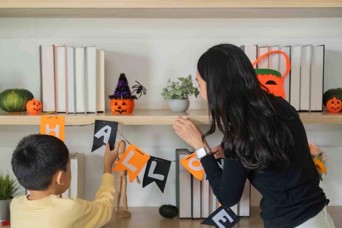 Madre e figlio decorano insieme la casa in occasione di Halloween
