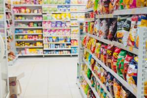 Merendine, snack e patatine esposti sugli scaffali di un supermercato